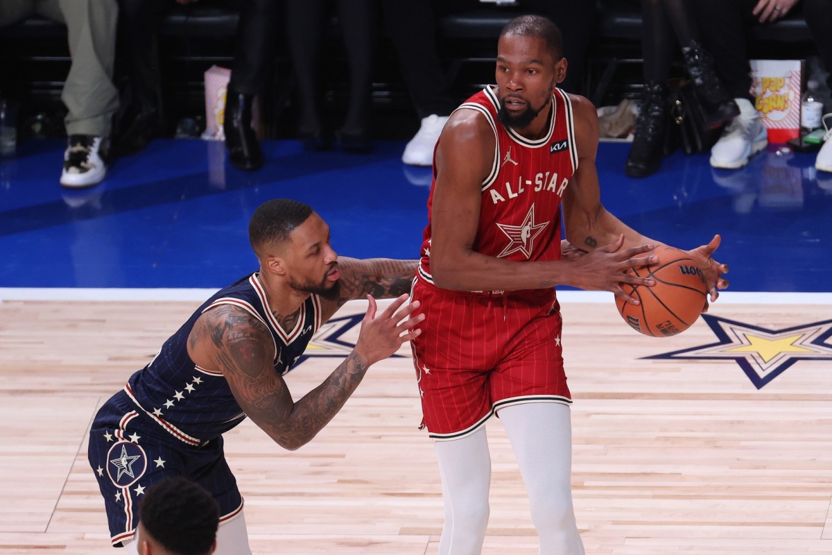Western Conference forward Kevin Durant (35) of the Phoenix Suns looks to pass the ball against Eastern Conference guard Damian Lillard (0) 